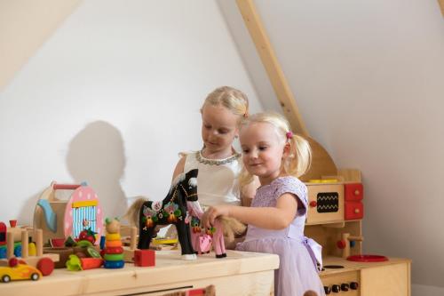two little girls playing with a sewing machine at Osada Gubałówka na Polanie Pająkówka & SPA in Kościelisko