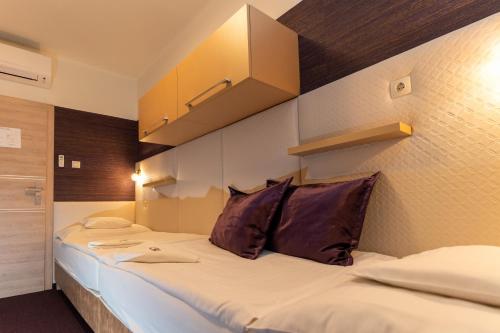a bedroom with a large bed with two pillows at Teátrum Boutique Hotel in Győr