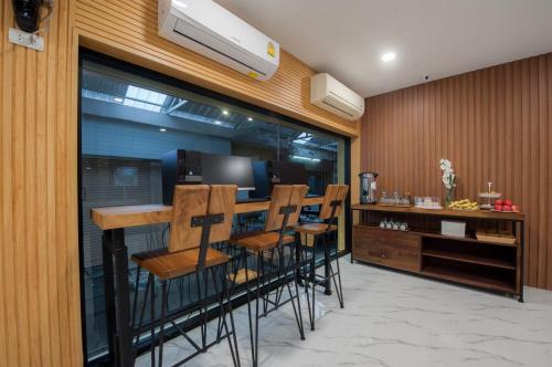 a bar with chairs and a counter in a room at The Moon Night Hotel in Bangkok