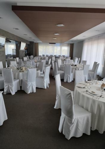 a banquet room with white tables and white chairs at ELITE HOTEL Nová Dubnica in Nová Dubnica