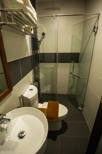 a bathroom with a toilet and a sink and a shower at RS Boutique Hotel in Kluang