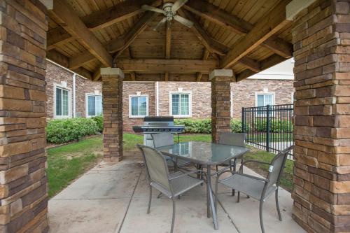 a patio with a table and chairs and a grill at Staybridge Suites Augusta by IHG in Augusta