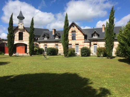 une grande maison avec une cour en gazon devant elle dans l'établissement La Bretauche, à Chécy