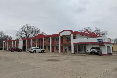 a large building with cars parked in a parking lot at Budget inn in Vandalia