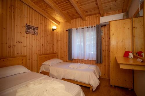 a bedroom with two beds and a window in it at Hotel Shpija e Gjyshit in Shkodër