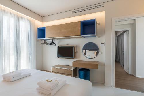 a hotel room with a bed and a television at Onira Suite Dreams in Hersonissos