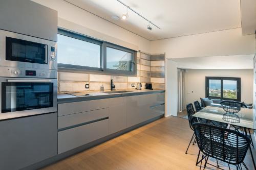 a kitchen with stainless steel appliances and a table with chairs at Onira Suite Dreams in Hersonissos