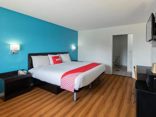 una camera con un grande letto con una parete blu di OYO Hotel DeRidder Hwy 171 North a DeRidder