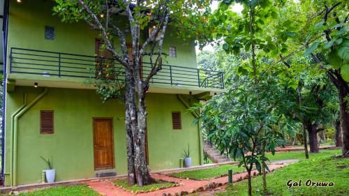 a green building with a balcony on the side of it at Gal Oruwa Resort in Dambulla