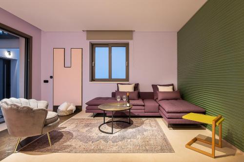 a living room with a couch and chairs and a table at Onira Suite Dreams in Hersonissos
