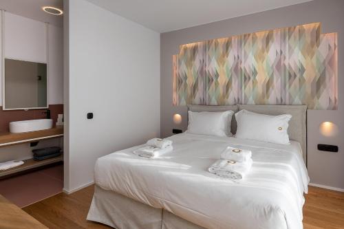 a bedroom with a white bed with towels on it at Onira Suite Dreams in Hersonissos