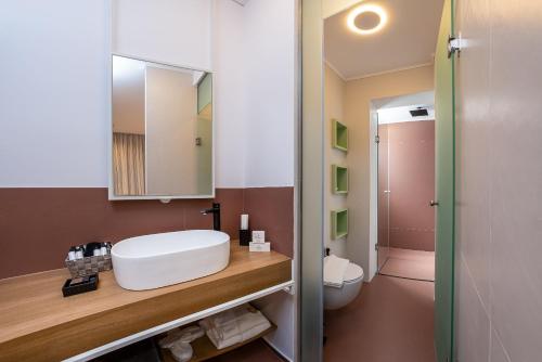 a bathroom with a white sink and a toilet at Onira Suite Dreams in Hersonissos