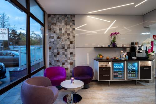 a coffee shop with purple chairs and a table at Hotel Stadt Heidelberg in Darmstadt