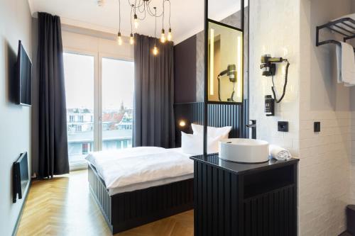 a bathroom with a bed and a sink and a mirror at 133 Boutique Hotel in Karlsruhe