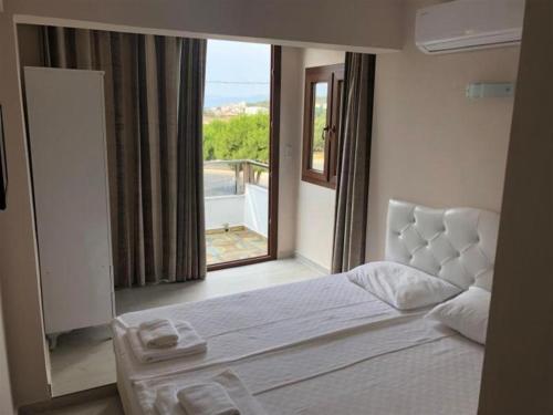 1 dormitorio con cama y ventana grande en Cesmeli Boutique Hotel - Çeşme, İzmir en Cesme