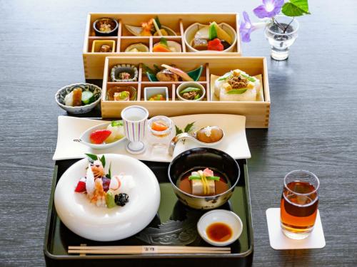 a tray of food on a table with dishes and drinks at Miyakojima Kurima Resort Seawood Hotel in Miyako Island