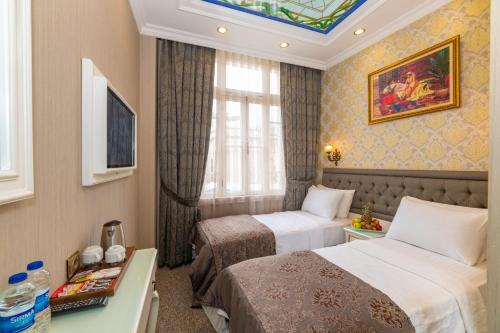 a hotel room with two beds and a window at Alpek Hotel in Istanbul