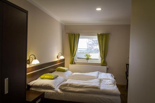 een slaapkamer met 2 bedden en een raam bij Penzion Na Netřebě in Pardubice