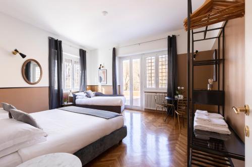 sypialnia z dwoma łóżkami i lustrem w obiekcie ROMAC San Saba 5-Bedroom and Terrace near Ostiense w Rzymie