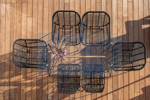three metal chairs and a table on a wall at Onira Suite Dreams in Hersonissos