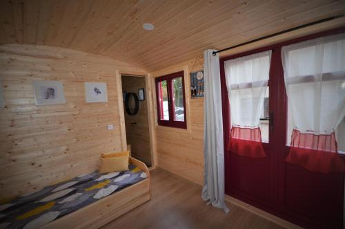 La Pommeraie-sur-SèvreにあるLe camp du fauconnierのベッドと窓が備わる小さな客室です。