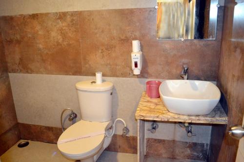 a bathroom with a toilet and a sink at Hotel Swagat in Mount Ābu