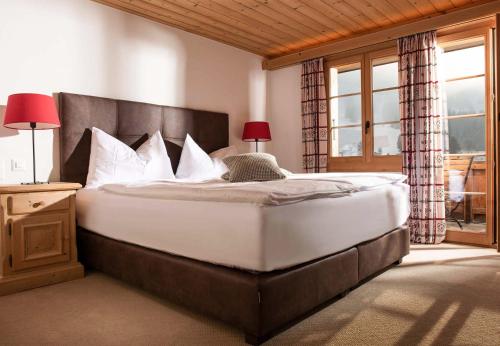 a bedroom with a large bed with white pillows at Hotel Kernen in Gstaad