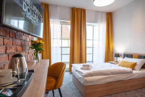sypialnia z łóżkiem i ścianą z cegły w obiekcie ApartHOTEL Gostyń w mieście Gostyń