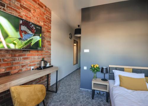 a room with a bed and a brick wall at ApartHOTEL Gostyń in Gostyń