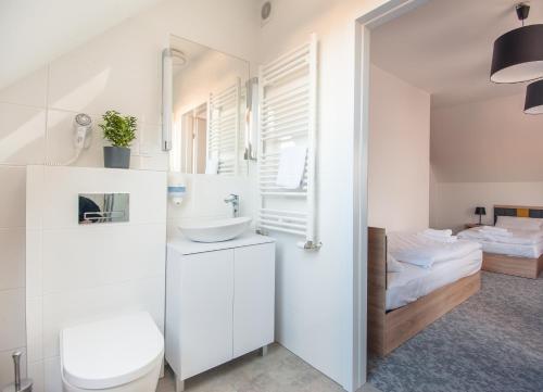 biała łazienka z umywalką i toaletą w obiekcie ApartHOTEL Gostyń w mieście Gostyń