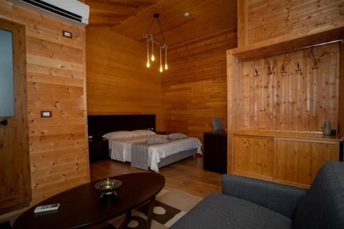 a bedroom with two beds in a room with wooden walls at Hotel Shpija e Gjyshit in Shkodër