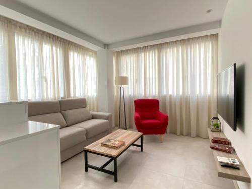 a living room with a couch and a red chair at HNN GRANADA in Granada