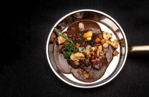 a bowl of food with meat and vegetables on a table at Hotel Kernen in Gstaad
