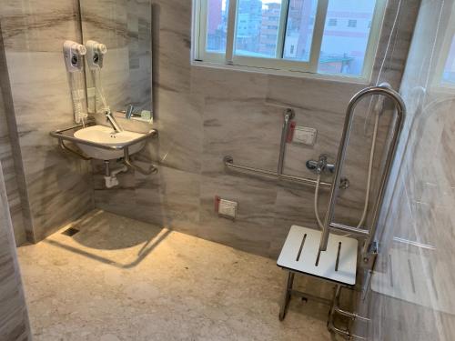 a bathroom with a sink and a mirror and a bench at Hotel Maple Taiwan Boulevard in Taichung