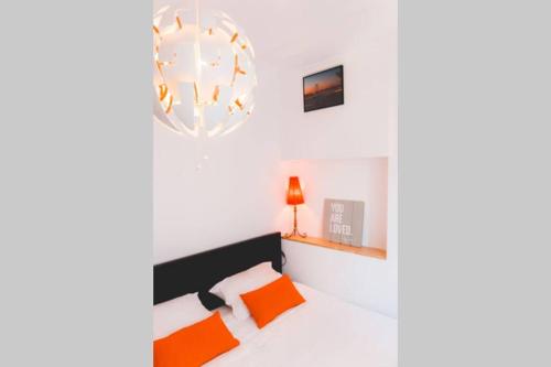 um quarto com uma cama com almofadas laranja em Welcome to Alcântara Apartment em Lisboa