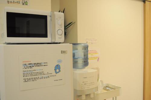 a microwave oven sitting on top of a refrigerator at 04village Namba in Osaka