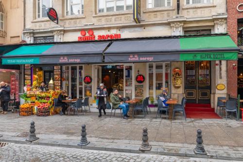 a group of people sitting at tables outside a store at Alpek Hotel in Istanbul