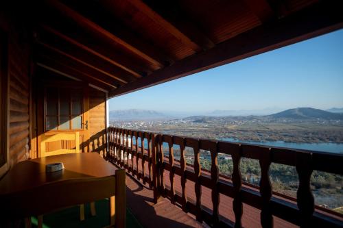 a balcony with a table and a view of the water at Hotel Shpija e Gjyshit in Shkodër
