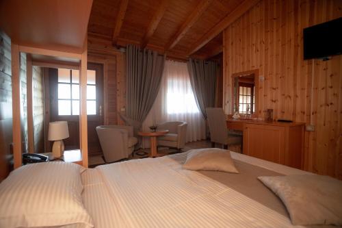 a bedroom with a large bed and a desk and a desk at Hotel Shpija e Gjyshit in Shkodër
