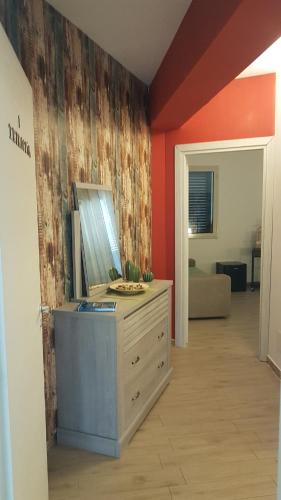 a room with a dresser and a red wall at La Porta dell'Alcantara in Gaggi