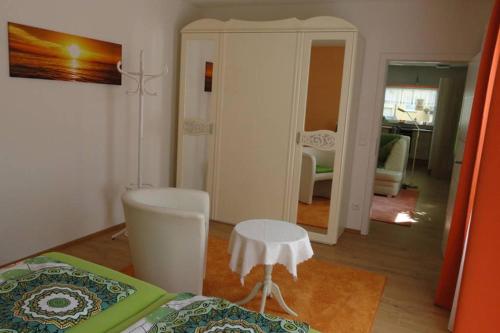 a bedroom with a bed and a chair and a mirror at Top 2 Zi-Wohnung, 350 m zum See in Friedrichshafen