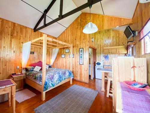1 dormitorio con 1 cama en una habitación de madera en Yorkdale Cabin, en Sabie