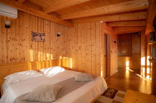 a bedroom with a bed in a wooden room at Hotel Shpija e Gjyshit in Shkodër