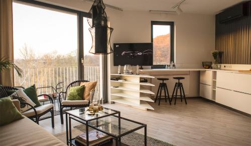 ein Wohnzimmer mit einem Sofa, einem Tisch und einer Küche in der Unterkunft Forest Park by Zoom Apartments in Bratislava