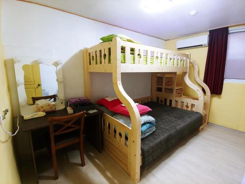 a bedroom with a bunk bed with a desk and a desk at Daejeon Guesthouse Sky Garden in Daejeon