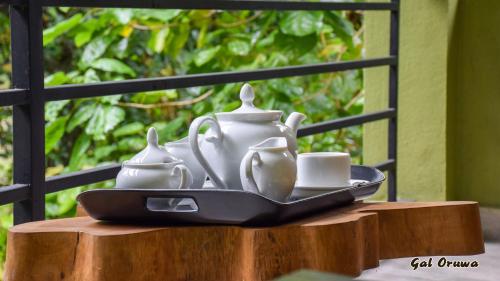 a tray with tea sets and cups on a table at Gal Oruwa Resort in Dambulla