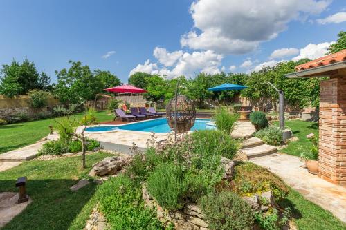 a backyard with a swimming pool and a garden at Beautiful villa Loreta with private pool near Pula and Rovinj in Čabrunići