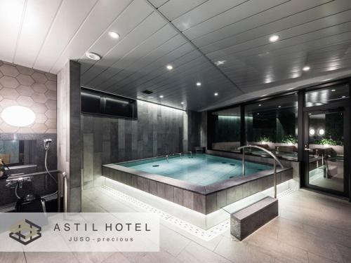 a large bathroom with a tub in the middle at Astil Hotel Juso Precious in Osaka