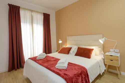 a bedroom with a large bed with two towels on it at APG Palau Salieti 2 in Girona