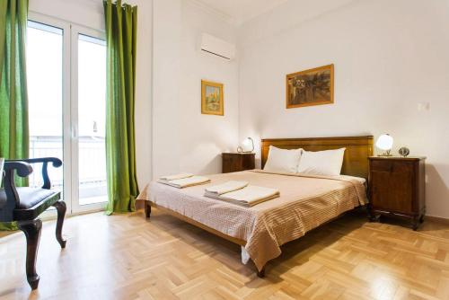 Athens Vintage Apartments - Pagrati في أثينا: غرفة نوم بسرير ونافذة كبيرة